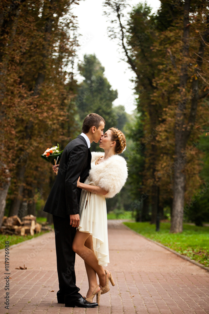 Fototapeta premium Groom kisses a bride with hair put in plait