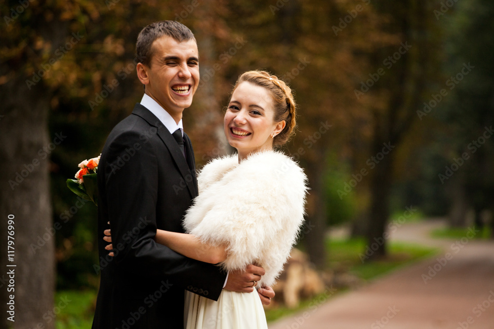 Smiling wedding couple dressed dimply poses in the park Smiling wedding couple dressed dimply poses in the park