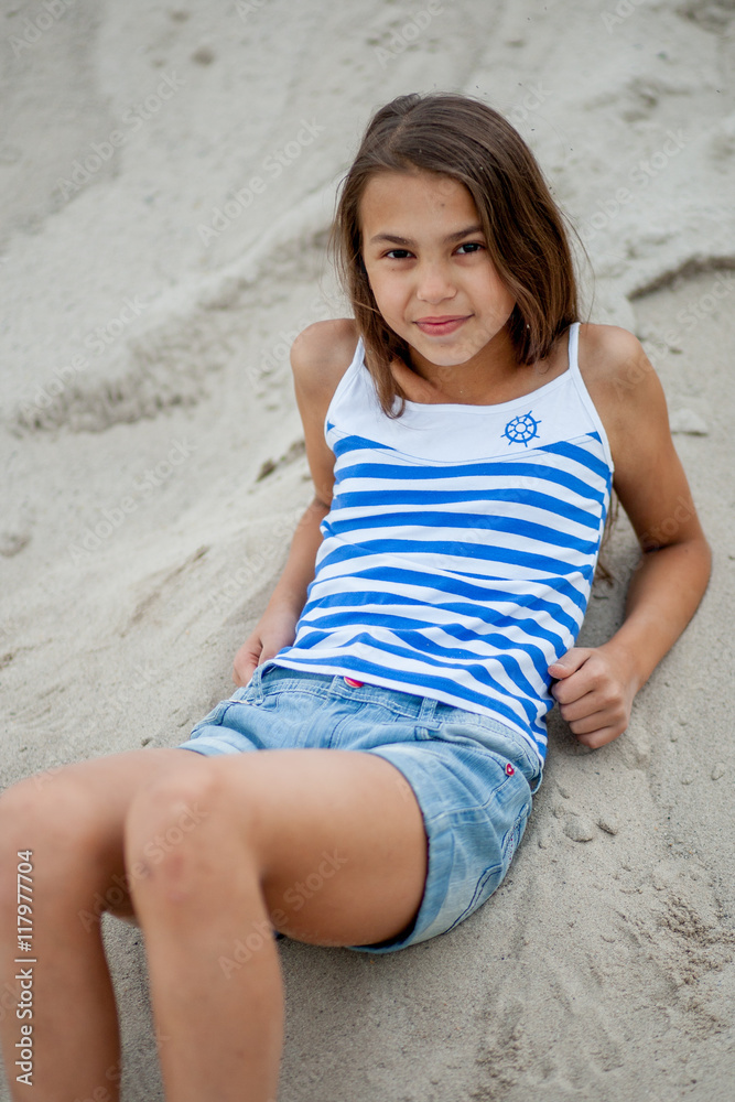 girl in a striped vest on the sand