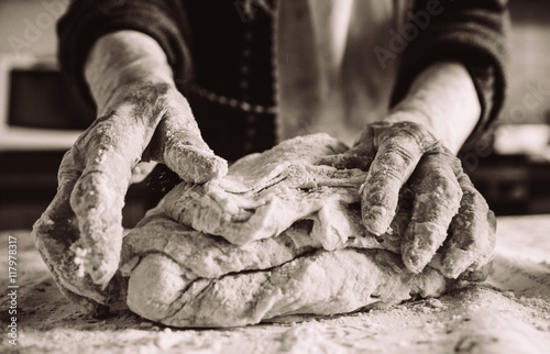 Fototapeta old  italian lady's hands making home made italian pasta
