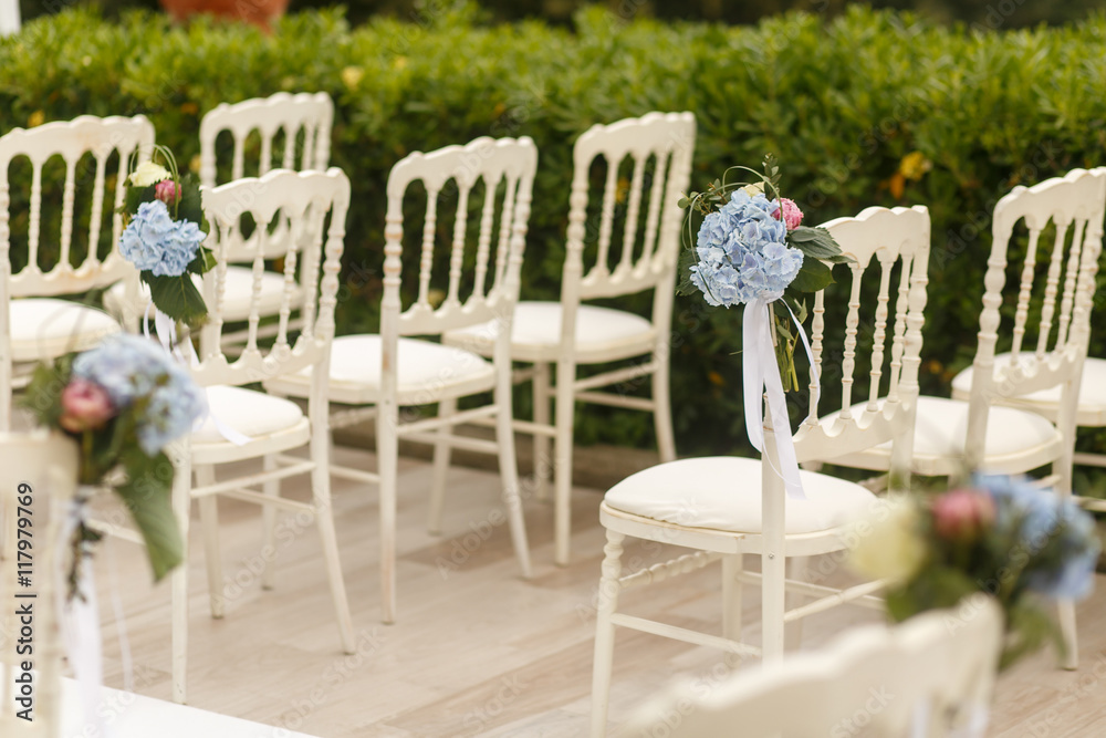 Blurred picture of blue hydrangeas put on white chairs Blurred picture of blue hydrangeas put on white chairs