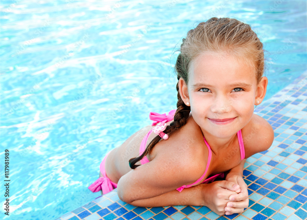 Adorable smiling little girl in swimming pool