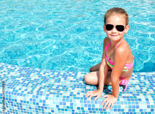 Adorable smiling little girl in swimming pool