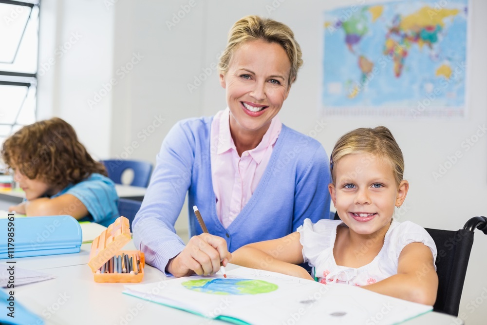 Teacher helping schoolgirl with her homework in classroom Teacher helping schoolgirl with her homework in classroom