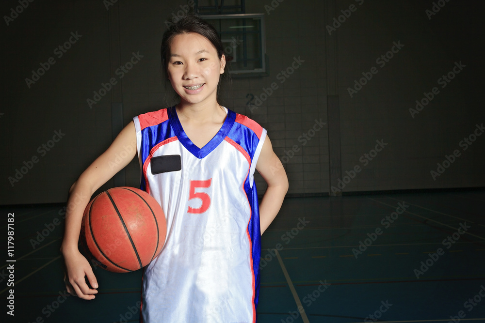 Naklejka premium A asian basketball player in gymnase field