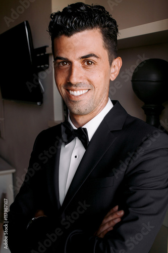 Smiling man with bronze skin corsses his hands on the chest photo