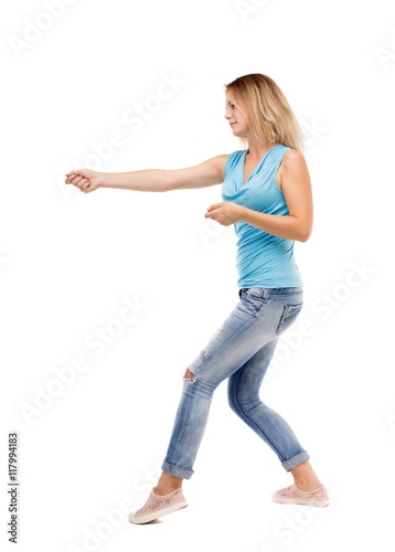 back view of standing girl pulling a rope from the top or cling to something. girl watching. Rear view people collection. backside view of person. Isolated over white background. The girl in jeans