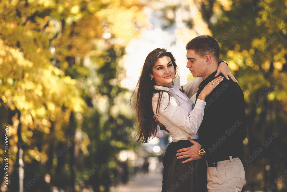 Man admires a gorgeous woman while posing in the autumn park Man admires a gorgeous woman while posing in the autumn park