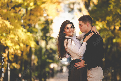Man admires a gorgeous woman while posing in the autumn park