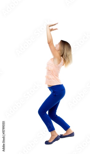 back view of woman protects hands from what is falling from above. woMan holding a heavy load Rear view people collection. backside view of person. Isolated over white background. The blonde in a