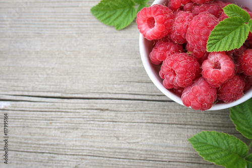 ripe raspberries in a bowl on the table