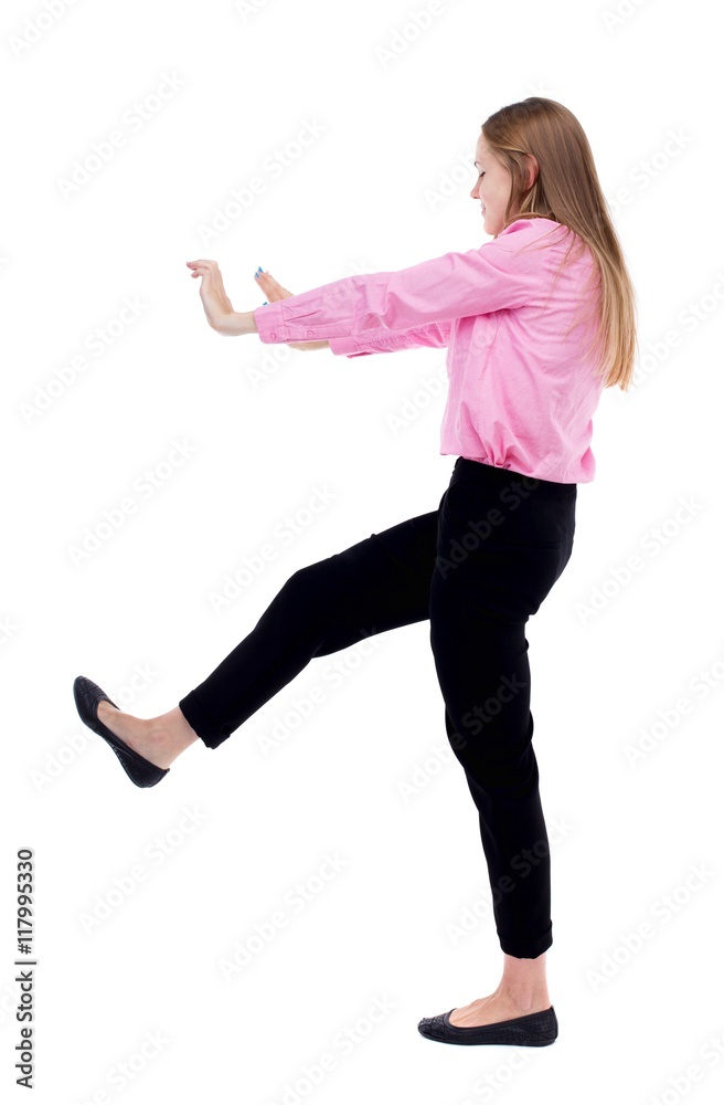 back view of business woman pushes wall.  Isolated over white background. Rear view people collection. backside view of person. Woman office worker in a pink shirt repels someone hands and feet.