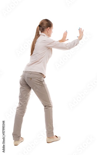 back view of woman pushes wall. Isolated over white background. Rear view people collection. backside view of person. Girl with long hair in a white jacket repelled