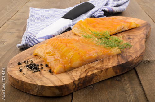 Fotografi smoked scottish haddock with dill on a wooden board