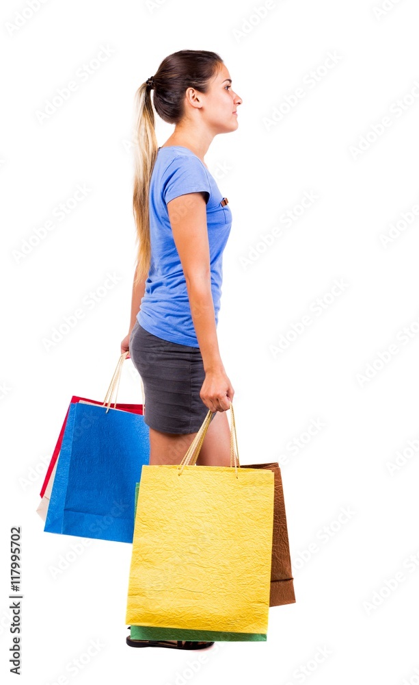back view of going woman with shopping bags . beautiful brunette girl in motion. backside view of person. Rear view people collection. Isolated over white background. Girl in a gray skirt and blue back view of going woman with shopping bags . beautiful brunette girl in motion. backside view of person. Rear view people collection. Isolated over white background. Girl in a gray skirt and blue