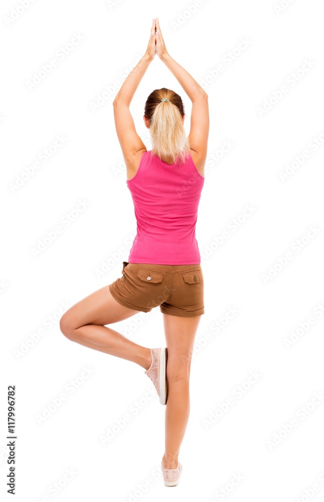 Back view of the girl standing in front of a warm up exercise.  Rear view people collection.  backside view of person.  Isolated over white background. The girl in brown shorts and a pink t-shirt