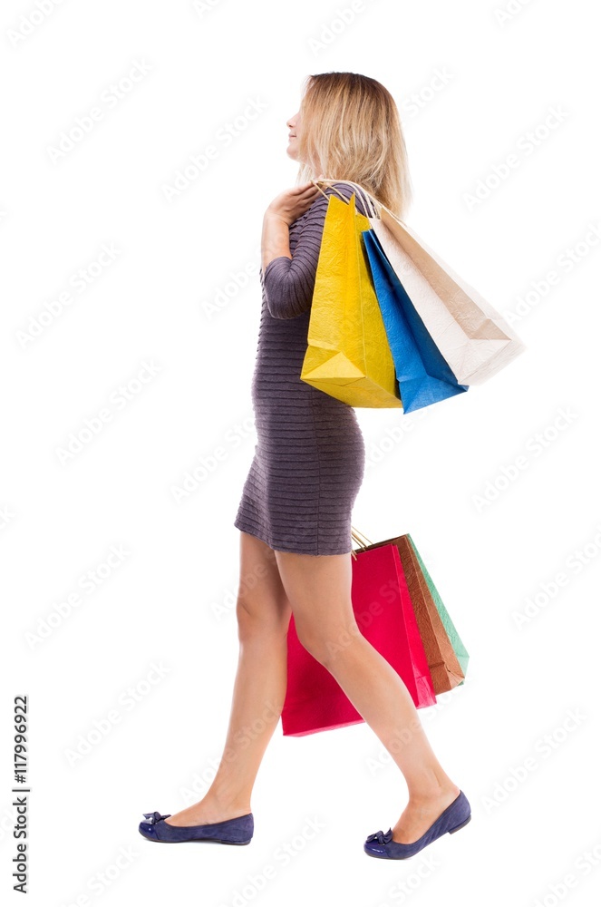 back view of going woman with shopping bags . beautiful girl in motion. backside view of person. Rear view people collection. Isolated over white background. Girl in a short dress is right back view of going woman with shopping bags . beautiful girl in motion. backside view of person. Rear view people collection. Isolated over white background. Girl in a short dress is right