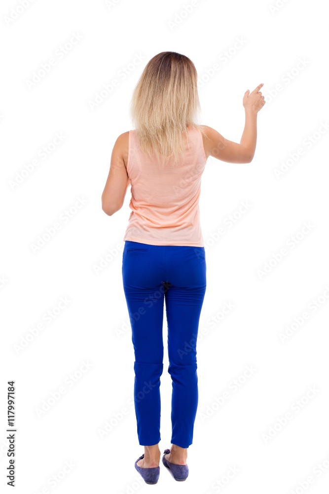 Back view of pointing woman. beautiful girl. Rear view people collection. backside view of person. Isolated over white background. blonde in blue pants is pointing with his left hand. Back view of pointing woman. beautiful girl. Rear view people collection. backside view of person. Isolated over white background. blonde in blue pants is pointing with his left hand.
