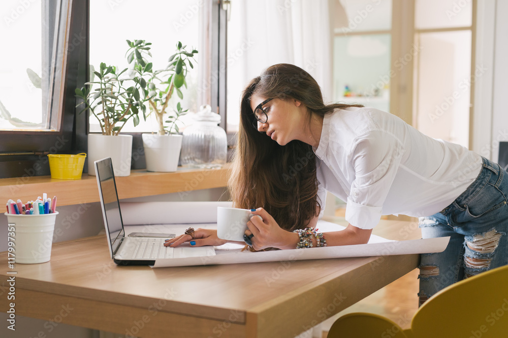 Running her business from home.young woman working on a computer in her home office Running her business from home.young woman working on a computer in her home office