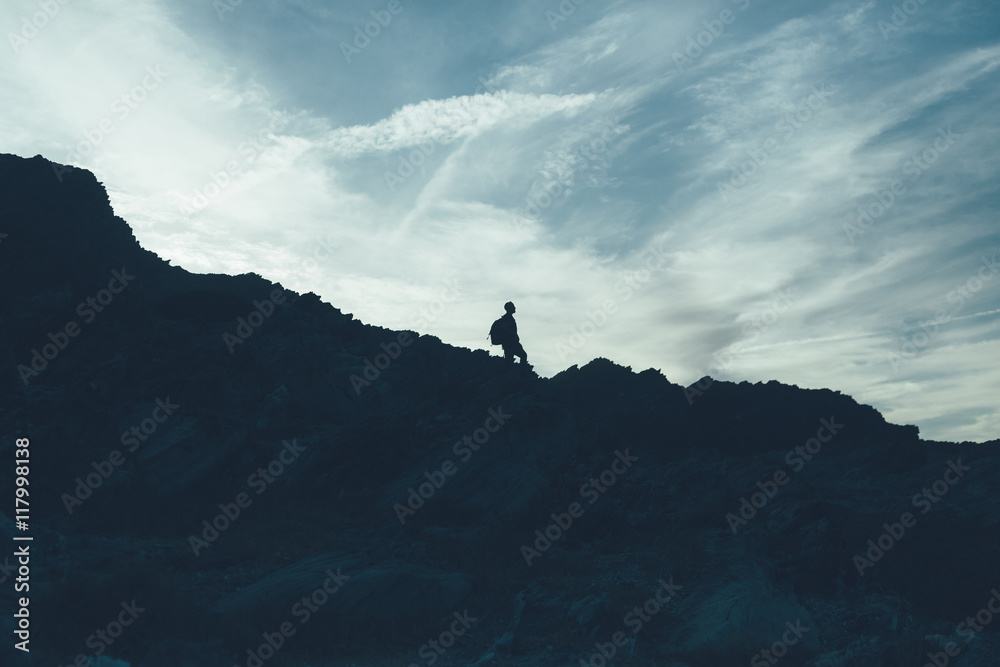 Back light silhouette of a man standing on a hill, overlooking,
