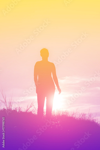  Silhouette of woman standing on the mountain at sunset