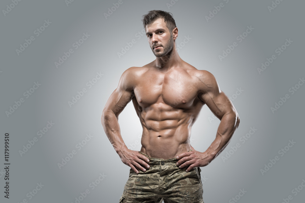 Muscular athlete bodybuilder man on a gray background Muscular athlete bodybuilder man on a gray background