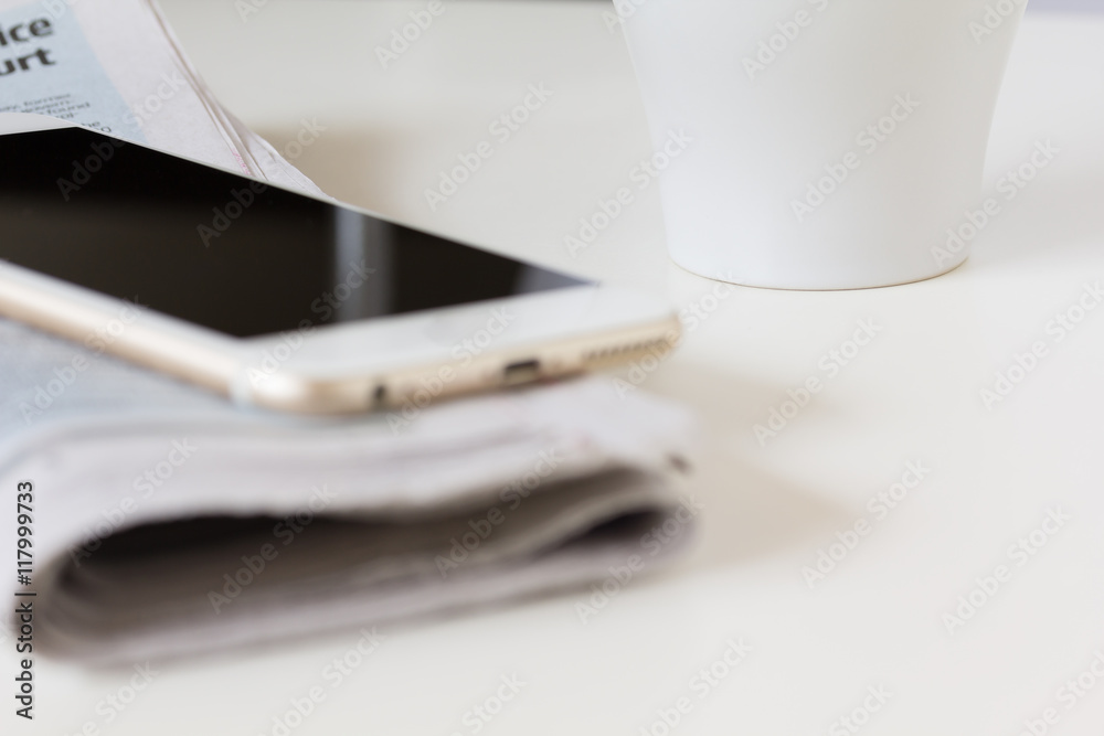 coffee cup with newspaper, smart phone on white table coffee cup with newspaper, smart phone on white table
