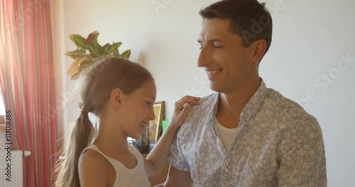 Charming portrait of happy father and daughter embracing at home interior background