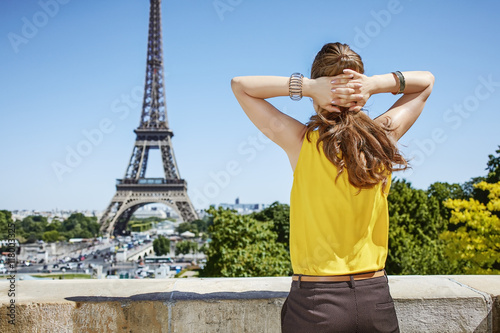 young woman relaxing in front of Eiffel tower in Paris, France © Alliance