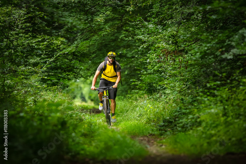 young mountain biker on single trail in green forest / Junger Mountainbiker auf singletrail im Wald