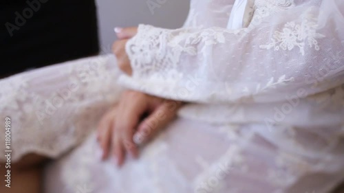 Beautiful lady in elegant white robe. Close up of hands with manicure indoors