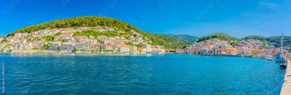 Fototapeta premium Pucisca town summer panorama. / Waterfront summer panorama at town Pucisca, picturesque place on Adriatic sea, Island of Brac, Croatia.