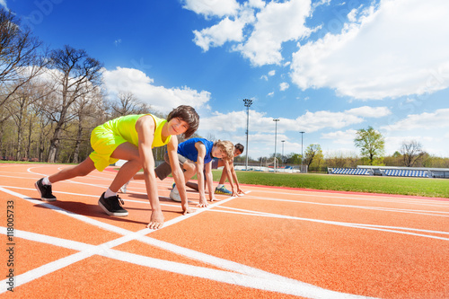 Three teenage athletes lined up ready to race