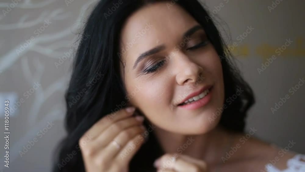 Beautiful gorgeous brunette bride in the morning. Posing anf putting on luxury earrings in the morning Beautiful gorgeous brunette bride in the morning. Posing anf putting on luxury earrings in the morning
