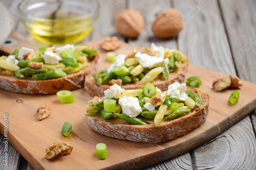 Bruschetta with french beans, green onions, feta cheese and walnuts, selective focus