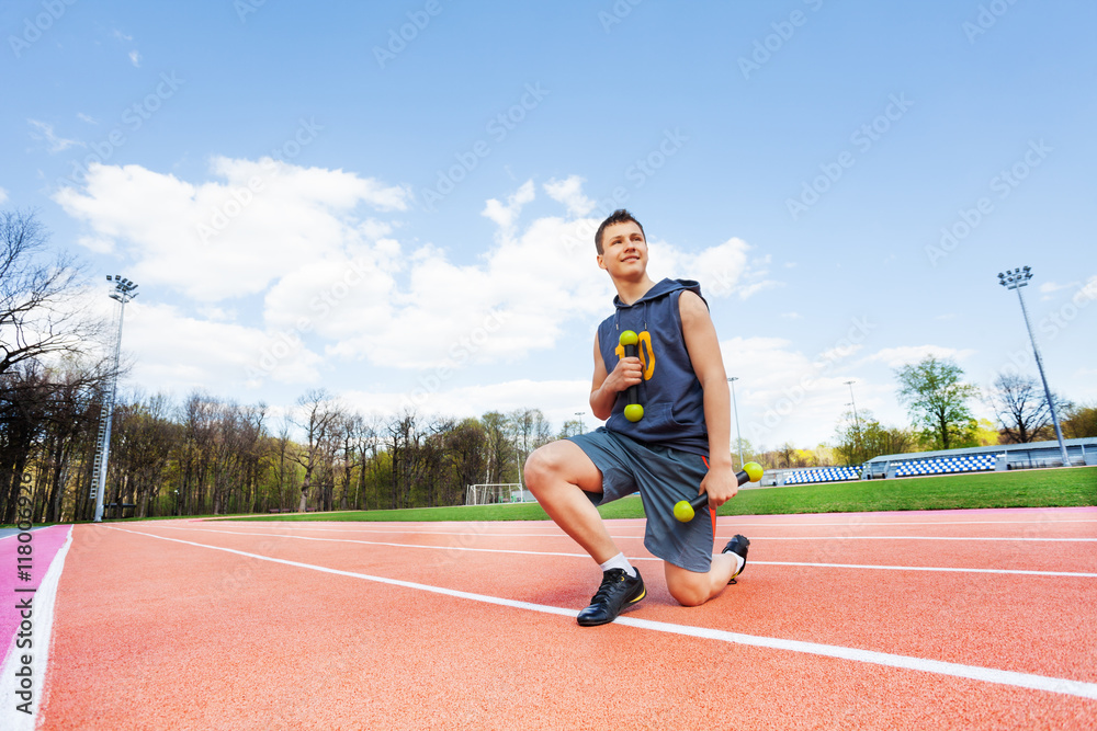 Fototapeta premium Picture of sporty boy with dumbbells in stadium