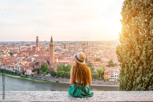 Woman enjoying beautiful view on Verona city in Italy on the sunset. Verona is famous city of love in the north of Italy.