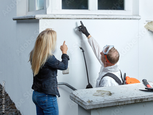 Pest controler explains something to a customer 