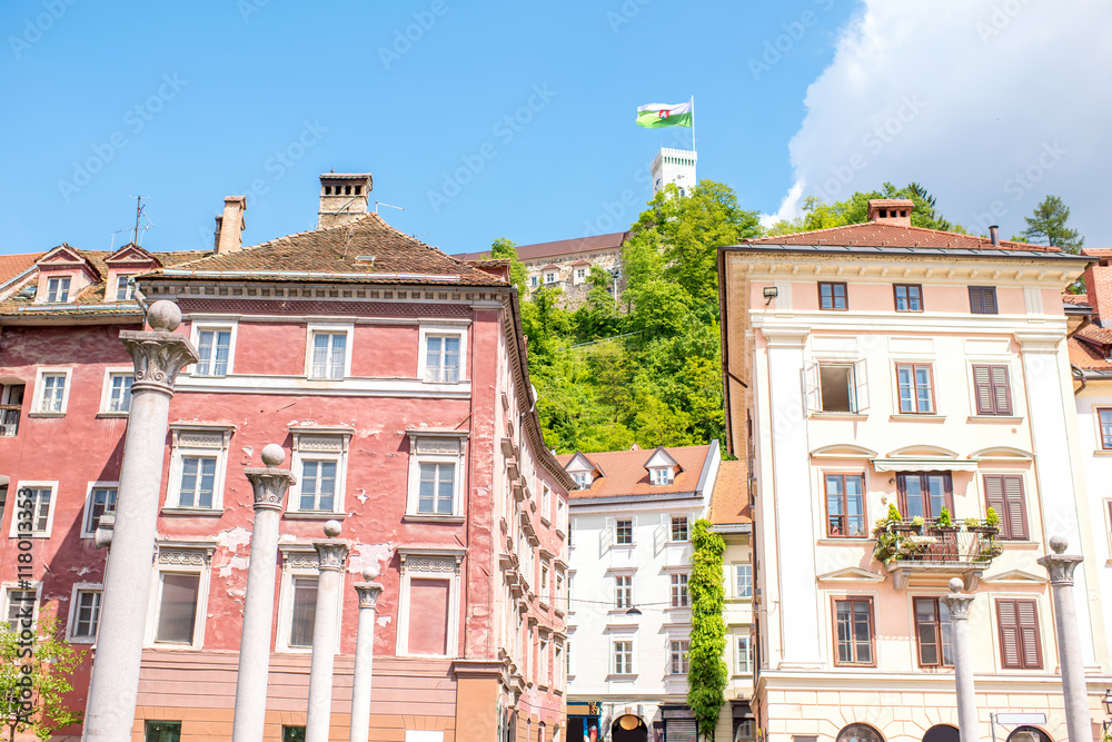 Old buildings with castle tower and slovenian flag in Ljubljana city