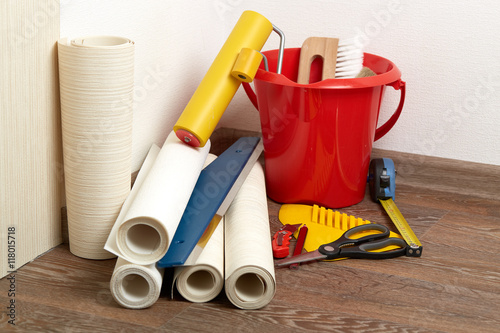 Rolls of wallpapers and various tools for wallpapering.