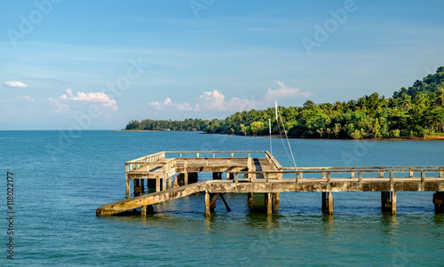 Fototapeta Naklejka Na Ścianę i Meble -  Port ferry boat with concrete ferry pier. Travel inspiration. Tropical landscape over sea with cloudy bright sky, Koh Chang island, Thailand.