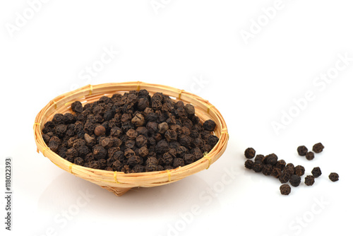 Black pepper, spices, medicinal properties in a basket on a white background.