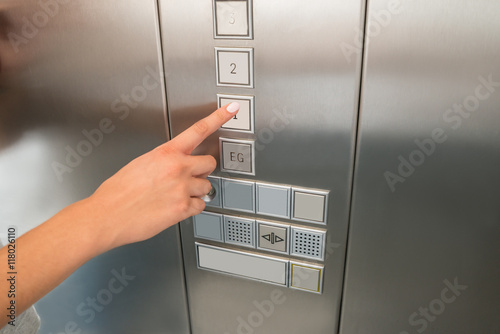 Female's Hand Pressing First Floor Button In Elevator