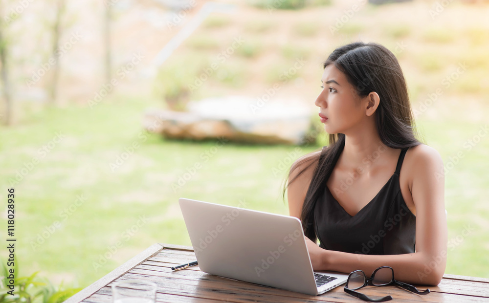 Young woman wearing smartwatch using laptop computer. Female wor Young woman wearing smartwatch using laptop computer. Female wor