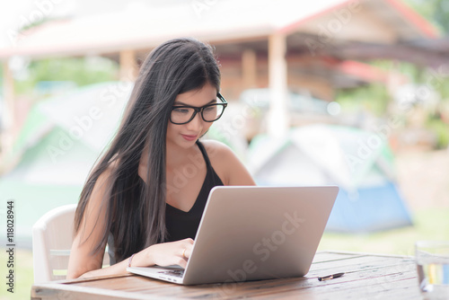 Young woman wearing smartwatch using laptop computer. Female wor