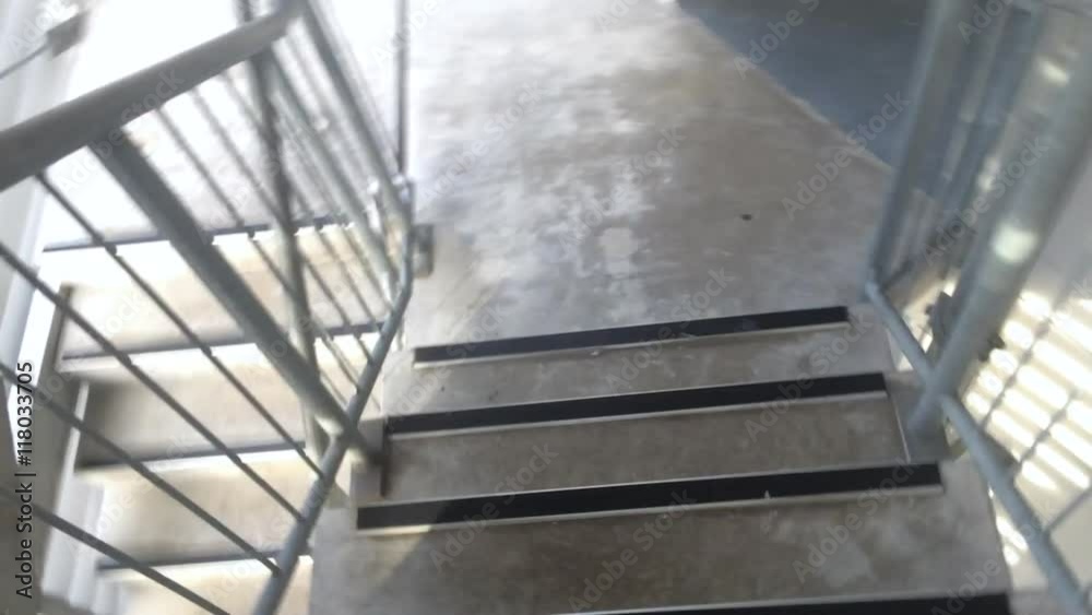 A person walks down emergency fire stairs. Personal point of view. Emergency concept. A person walks down emergency fire stairs. Personal point of view. Emergency concept.