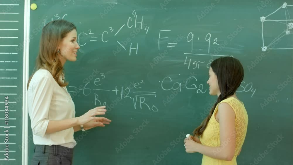 pretty young female college student writing on the chalkboard blackboard during a chemistry class pretty young female college student writing on the chalkboard blackboard during a chemistry class