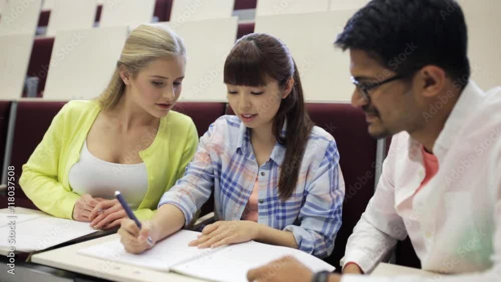 group of students with notebooks in lecture hall group of students with notebooks in lecture hall