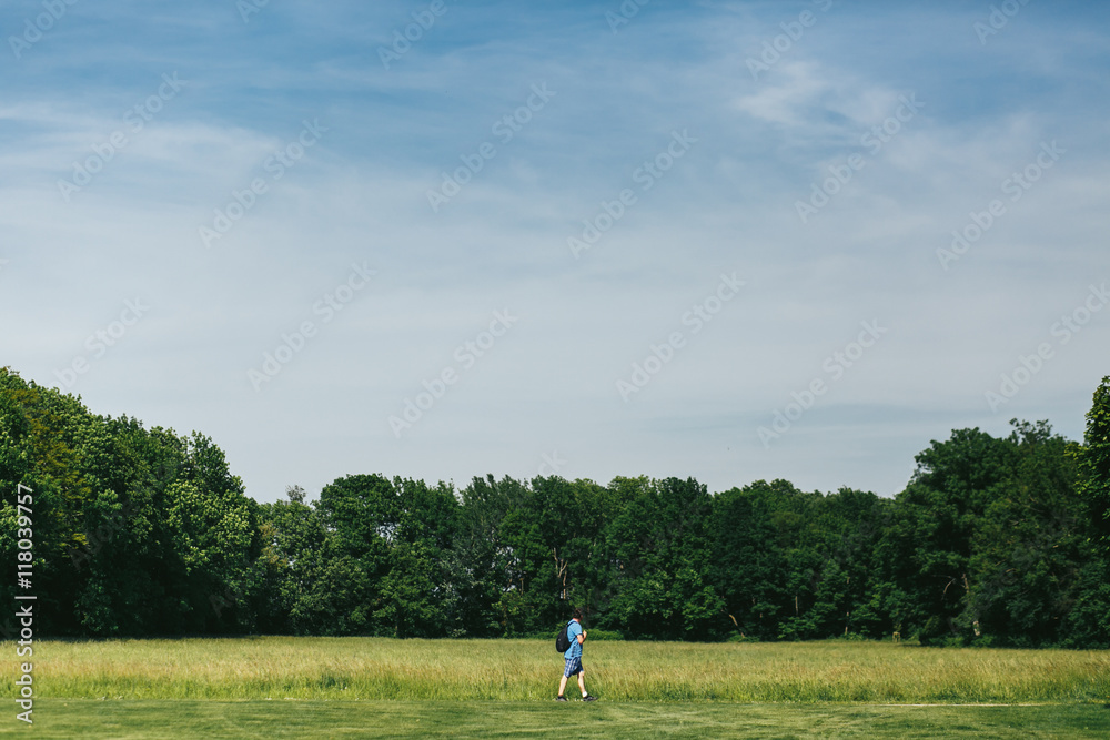 Man in blue shorts walk along the green lawn