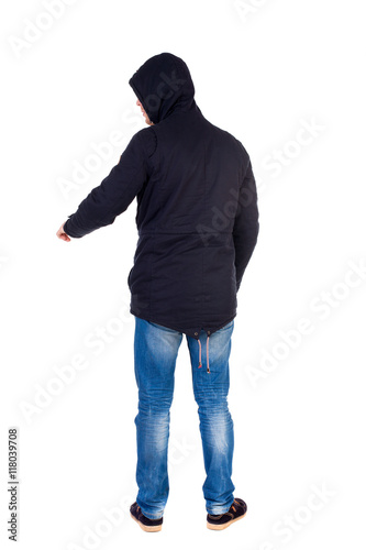 Back view of pointing young men in parka. Young guy gesture. Rear view people collection. backside view of person. Isolated over white background. The guy while wearing a hood on his head is